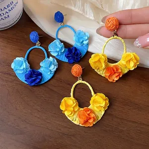Handmade raffia fabric flower earrings featuring vibrant blue and yellow petals for vacation