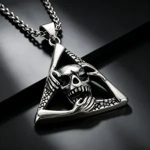 Makro-Detail eines Vintage-Edelstahlanhängers mit gotischem Totenkopf im Dreieck-Rahmen