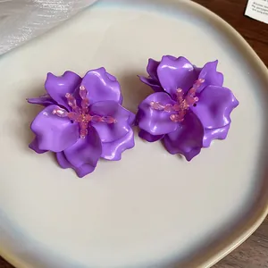 Detailed close-up of purple acrylic 3D flower earrings with pink bead accents
