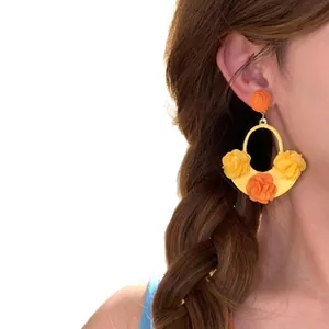 Statement floral drop earrings for beach vacation with yellow and orange fabric flowers.