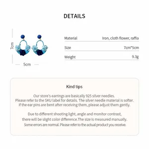 Detailed view of blue raffia cloth flower earrings with size and weight specifications