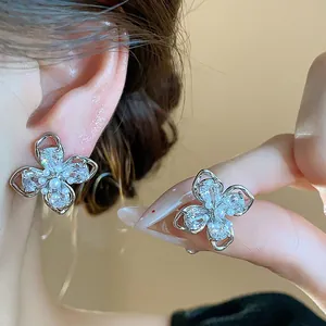 Close-up detail of elegant four-leaf flower stud earrings with crystals and pearls