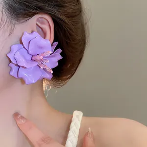 Detail view of stylish large purple acrylic 3D flower earring for a summer beach look