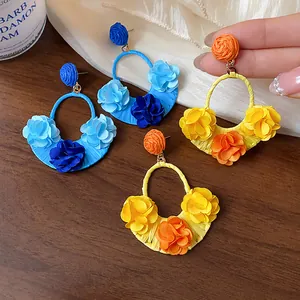 Detailed close-up of colorful raffia fabric flower earrings in vacation style