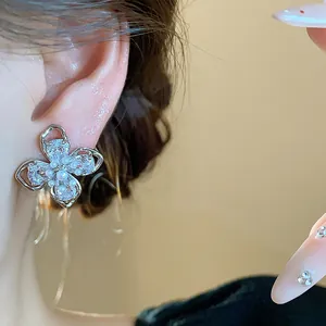 Close-up detail of 18k gold-plated flower stud earring with zirconia and pearls