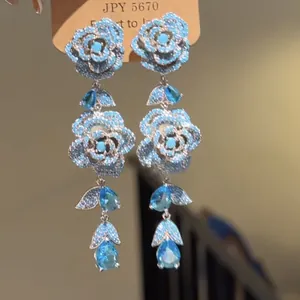 Vista dettagliata di orecchini pendenti con rose di cristallo blu e dettagli in argento