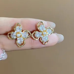 Detailed macro view of 18k gold plated flower stud earrings with CZ and pearls