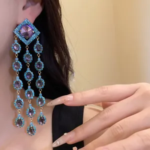Detail shot of vintage tassel earrings with purple zircons and turquoise beads.