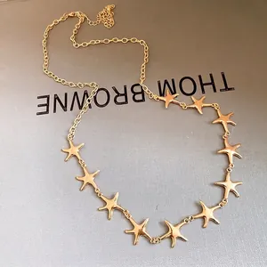 Elegante goldfarbene Halskette mit mehreren Seestern-Anhängern auf grauem Hintergrund