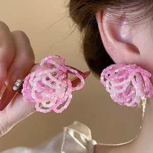 High-definition close-up of handmade pink beaded flower earrings with silver needles