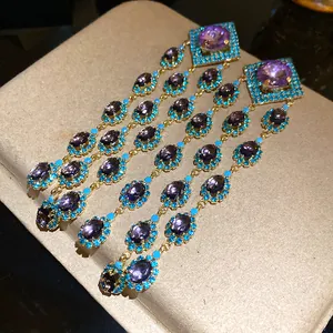Close-up detail of vintage dangle earrings with purple stones and turquoise accents