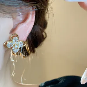 Detailed view of 18k gold plated flower stud earrings with pearls and sparkly zircons