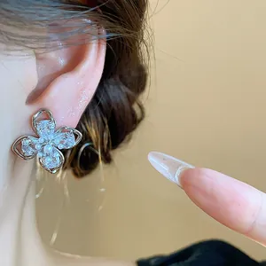 Detailed close-up shot of an elegant silver flower earring with zircons and a pearl
