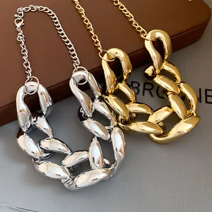 Close-up of chunky hip-hop style chain necklaces in gold and silver metallic finishes.