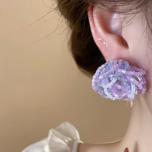 Detail view of elegant purple beaded flower stud earrings with a silver needle post