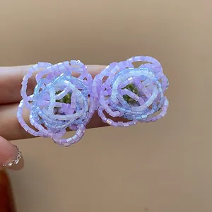 Close-up of elegant handmade purple beaded flower stud earrings showing intricate glass petals