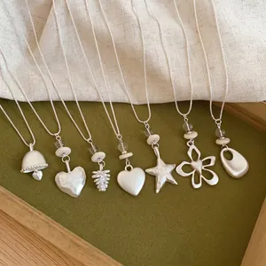 Collection of geometric star and flower pendant necklaces in matte silver finish