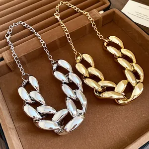 Detailed view of chunky gold and silver punk style curb necklaces in a jewelry box