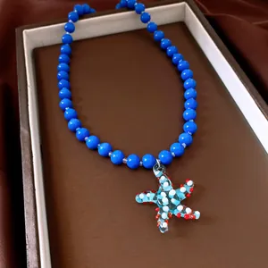 Nahaufnahme einer blauen Perlenkette mit einem einzigartigen Seesternanhänger aus Glas