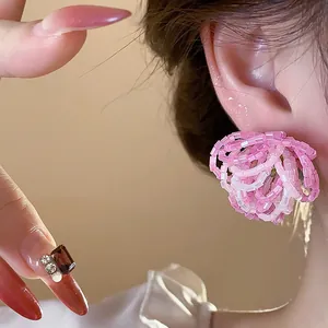 Close-up of elegant pink glass beaded flower stud earrings on a model's ear.