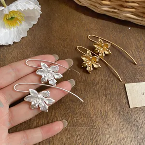 Detaillierte Nahaufnahme von floralen Ohrhaken im Vintage-Stil in Gold und Silber matt