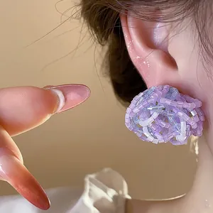 Detailed close-up showing the intricate purple beaded glass flower design of these stud earrings.
