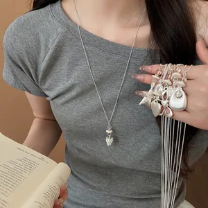 Detailed view of trendy silver-toned necklaces featuring star and heart charms.