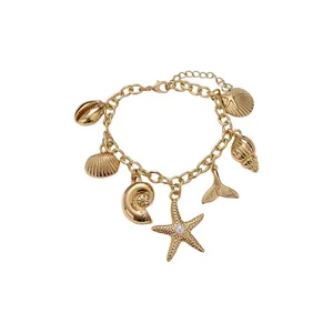 Elegantem goldenen Ozean-Charm-Armband mit Seestern- und Muschel-Anhängern auf weißem Grund