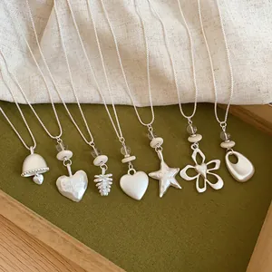 Detailed view of silver-toned necklaces with star, heart, and flower pendants