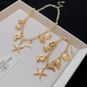 Detailansicht der goldfarbenen Ozean-Halskette und des Armbands mit Muschelanhängern