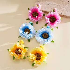 Nahaufnahme von bunten Raffia-Stoffblumen-Ohrringen auf einem Stein-Hintergrund
