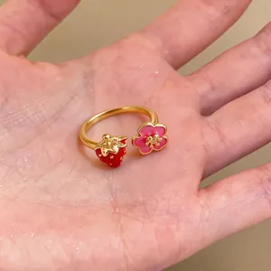 Close-up of cute strawberry and flower open ring on palm