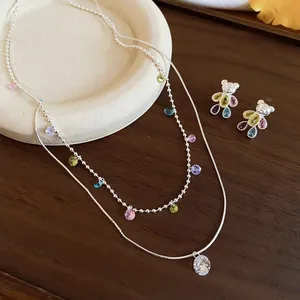 Vue détaillée d'un ensemble de bijoux ours coloré avec collier et boucles d'oreilles.
