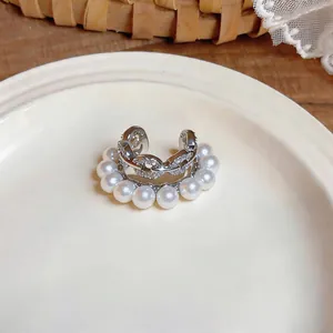 Macro detail of silver-toned double layer ear cuff with white pearls and sparkling cubic zirconia