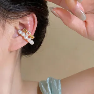 Close-up detail of a double-layer pearl and sparkling zircon ear cuff on model ear