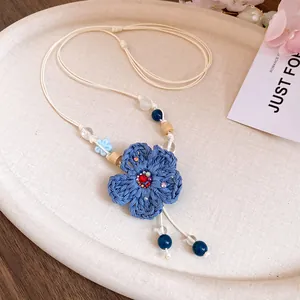 Handmade woven blue flower pendant necklace with beads and wooden accents for vacation