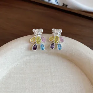 Détail macro d'exquises boucles d'oreilles ours en argent avec des zircons gouttes colorés