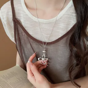 Elegant silver hollow flower pendant necklace worn by model in minimalist setting