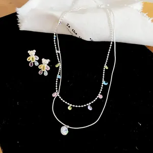 Vue détaillée du collier en argent et des boucles d'oreilles ours en pierres colorées
