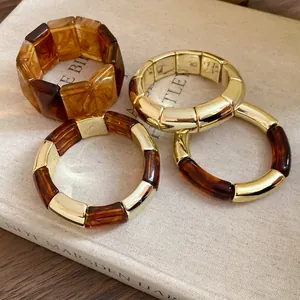 Detailed view of Maillard style acrylic and gold-tone metal chunky link bracelets