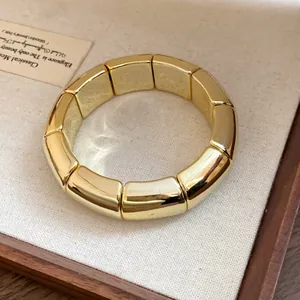 Detailed view of a gold segmented acrylic bracelet in a wooden box
