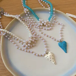 Elegant multi-layer pearl necklace with beaded flowers and studded heart pendant for women