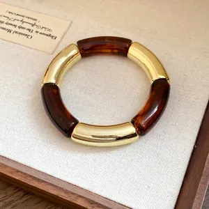 Detailed macro view of acrylic and gold segmented bracelet with tortoiseshell pattern