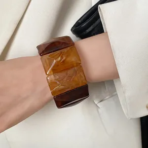 Close-up macro view of Maillard style acrylic chunky bracelet with amber texture on a wrist