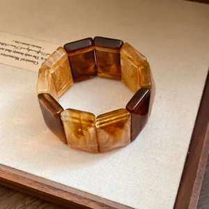 Close-up of Maillard style amber acrylic block bracelet in a wooden jewelry box