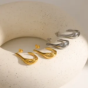 Detaillierte Makroansicht minimalistischer U-förmiger Edelstahl-Ohrringe in Gold und Silber
