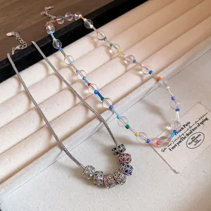 Close-up of bohemian crystal beaded necklace and silver snake chain with charms.