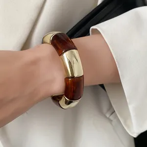 Chunky amber acrylic and gold metal segment stretch bracelet worn on wrist detail