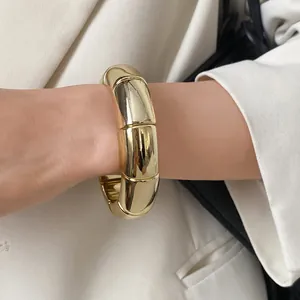 Detailed view of a gold-finished segmented acrylic bracelet on a model's wrist