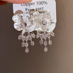Dettaglio degli orecchini a fiore in resina con nappe in zirconia scintillante eleganti